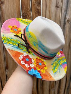 Introducing this one-of-a-kind Tropical Dreams Hard Felt Wide Brim Fedora Hat. Crafted with precision, this unique hat is made from durable hard felt, ensuring a lasting accessory that stands out in any crowd. This unique hat boasts a beige, cream-colored, hard felt canvas, providing the perfect foundation for the hand-painted tropical elements that make this piece truly one-of-a-kind. On one side, envision a nod to island living with a tropical motif that adds a touch of exotic charm. Flip it over, and discover another side featuring nature's vibrant beauty, adding versatility to your style. Ideal for those seeking a statement piece, the one-of-a-kind Tropical Dreams Hat is crafted with care and designed to elevate any ensemble. The hard felt construction ensures durability, while the wid