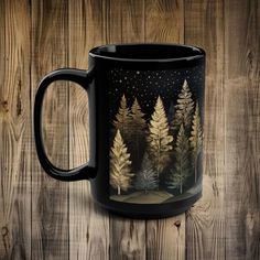 a black coffee mug sitting on top of a wooden table next to a wood wall