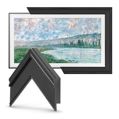 a painting hanging on the wall next to a frame with an image of a lake