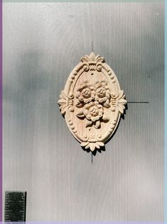 a decorative plaque on the side of a building with a blue sky in the background