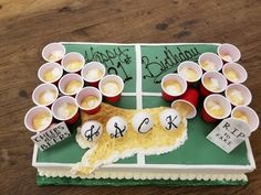 a cake made to look like a football field with cups on it and happy birthday written on the side