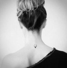 the back of a woman's neck with tattoos on it