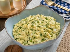 a blue bowl filled with mashed potatoes on top of a table