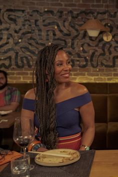 a woman with long braids sitting at a table