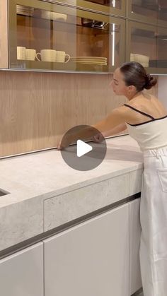 a woman standing in front of a kitchen sink