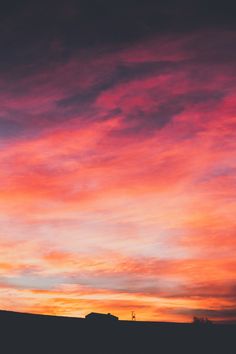 the sky is pink and orange with clouds