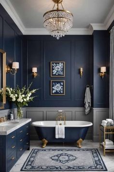 an elegant bathroom with blue walls and gold fixtures, chandelier above the bathtub