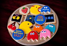 decorated cookies on a plate with pacman faces and other items in the shape of pacman