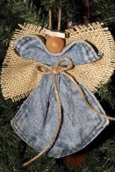 an angel ornament hanging from a christmas tree with blue jeans and burlocks