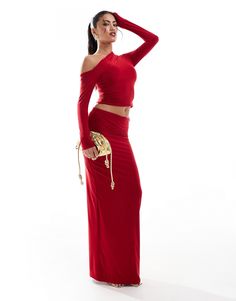 a woman in a long red dress posing for the camera with her hand on her hip