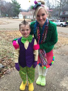 a woman standing next to a child wearing clown costumes