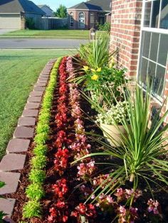 a flower bed in front of a house with flowers growing out of it and the words pinterest 37 best images about yard / flower bed ideas