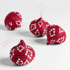 three red and white ornaments hanging from string