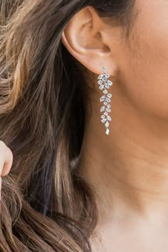 a close up of a woman's ear wearing a pair of white diamond earrings