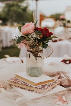 a vase filled with flowers sitting on top of a table covered in white linens