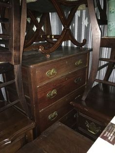 an old wooden dresser and chair in a room