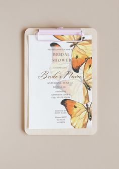 a yellow and black butterfly themed bridal shower card with a pink pen on it