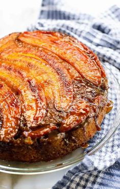 a pineapple upside down cake on a glass plate with a blue and white checkered napkin