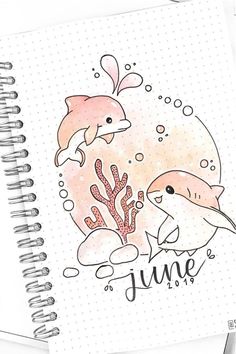 a spiral notebook with dolphins and corals on it