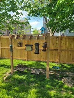 a wooden fence with bird feeders attached to it