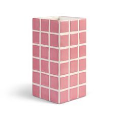 a pink vase sitting on top of a white table