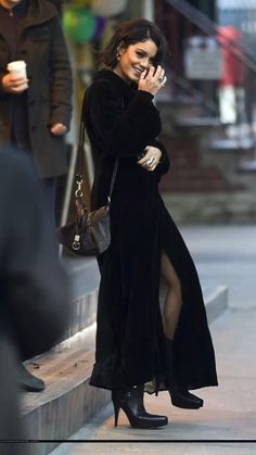 a woman is talking on her cell phone while walking down the street with other people