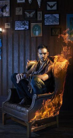 a man sitting on top of a chair covered in fire