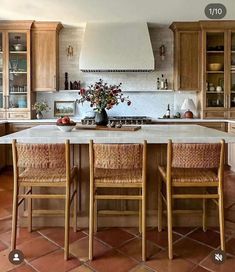 a large kitchen with wooden cabinets and white marble counter tops is pictured in this image