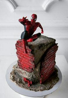 there is a cake made to look like a spiderman on top of a brick wall