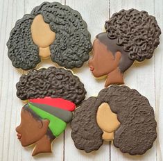 four decorated cookies with black women's hair on top of each cookie, one is brown and the other is green