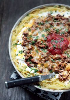 a pan filled with spaghetti and meat on top of a table