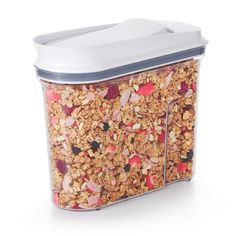 a plastic container filled with granola on top of a white table next to a canister