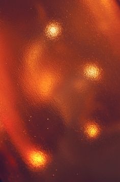 a close up view of an orange colored substance with some light shining on it's surface