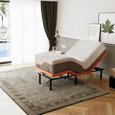 a bed sitting on top of a wooden floor next to a window