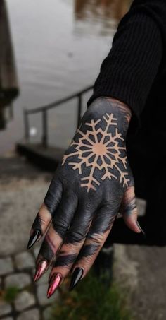 a woman's hand with black and white tattoos on it