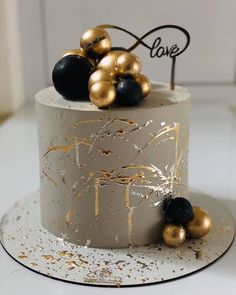 there is a cake with gold and black decorations on it