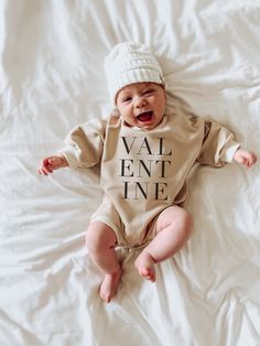 "Celebrate the day of love with this cozy cotton cream baby sweatshirt bubble romper featuring the text \"valentine\". Makes a great baby shower gift, pregnancy announcement, or first valentines day outfit. This soft bodysuit is the perfect light sweatshirt material layer for baby. It is unisex in design, perfect for girl and boy adventurers alike! Item fits large and runs large as the style is oversized. The fit is a retro oversized width, styled to be relaxed and loungey. This product is handp Long Sleeve Onesie With Letter Print For Playtime, Cream Long Sleeve Onesie For Playtime, White Long Sleeve Onesie Gift, Beige Long Sleeve Onesie For Playtime, Baby Boy Valentines Day Outfit, Baby First Valentines Day, Baby Boy Valentine Outfit, Baby Boy Valentines, Month Milestones