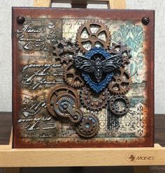 a wooden easel holding an art piece made out of metal gears and other things