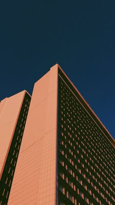 a very tall building with a clock on it's side in front of a blue sky