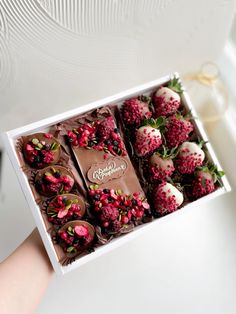 chocolate covered strawberries in a white box with pink and green flowers on the side