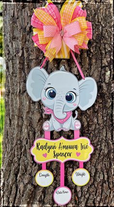 a sign on the side of a tree with an elephant hanging from it's trunk