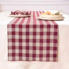 two plates with food on them sitting on top of a white tablecloth covered table