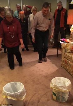 a group of people standing around in a living room