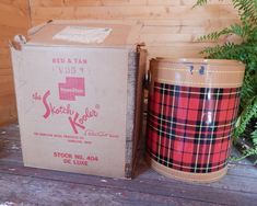 two red and tan tins sitting next to each other on a wooden floor near plants