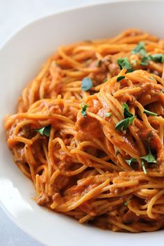 a white bowl filled with spaghetti and sauce