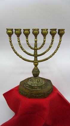 a golden menorah on a red cloth