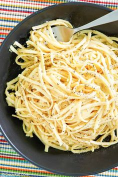 a skillet filled with pasta on top of a table