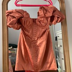 a dress hanging on a clothes rack in front of a mirror