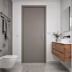 a bathroom with a white toilet sitting next to a walk in shower and a sink