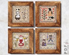 four framed cross - stitch pictures in wooden frames